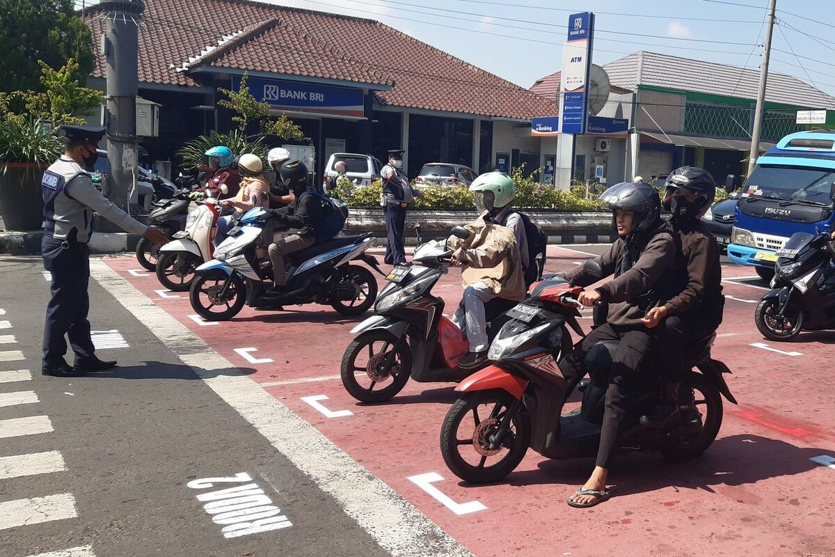 Para pengguna kendaraan roda dua berhenti di marka pembatasan jarak 1 meter di traffic light Simpang Lima Sukoharjo, Jawa Tengah, Rabu (10/6/2020).