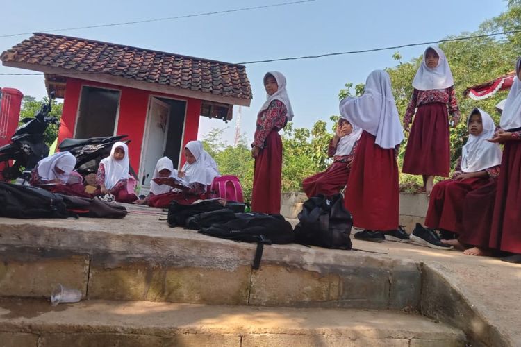 Sejumlah siswa SD di Cianjur, Jawa Barat terpaksa belajar di luar akibat ruang kelas rusak dampak gempa tahun lalu.