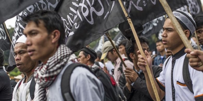 Massa dari Hizbut Tahrir Indonesia membawa bendera saat demo di Jakarta pada 18 Juli 2017. Mereka menentang rencana pemerintah yang akan membubarkan HTI. 