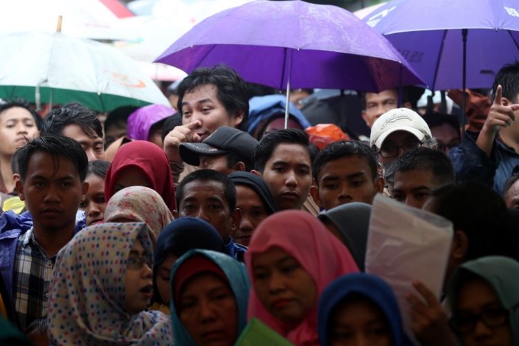 Warga antre menyerahkan berkas untuk pencetakan e-KTP di stan pelayanan dan pencetakan e-KTP di Taman Mini Indonesia Indah (TMII), Jakarta, Jumat (20/10/2017).  Kegiatan yang digelar antara Dinas Kependudukan dan Catatan Sipil DKI bekerja sama dengan Direktorat Jenderal Kependudukan dan Catatan Sipil Kementerian Dalam Negeri ramai diserbu warga yang yang belum memiliki e-KTP. KOMPAS IMAGES/KRISTIANTO PURNOMO
