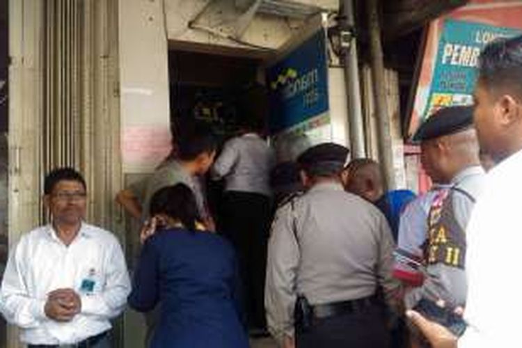 Sejumlah anggota polisi dan pegawai Bank Mandiri memeriksa mesin Anjungan Tunai Mandiri (ATM) yang dibobol maling di Jalan Sultan Babullah, Kecamatan Sirimau AMbon, Selasa (4/10/2016)