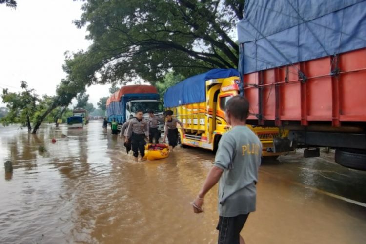 BANJIR --Ruas jalan nasional Madiun-Ngawi putus total menyusul banjir yang melanda wilayah itu sejak Rabu (6/3/2019) dinihari. Nampak truk dan mobil yang terjebak berhenti menunggu air banjir surut. 