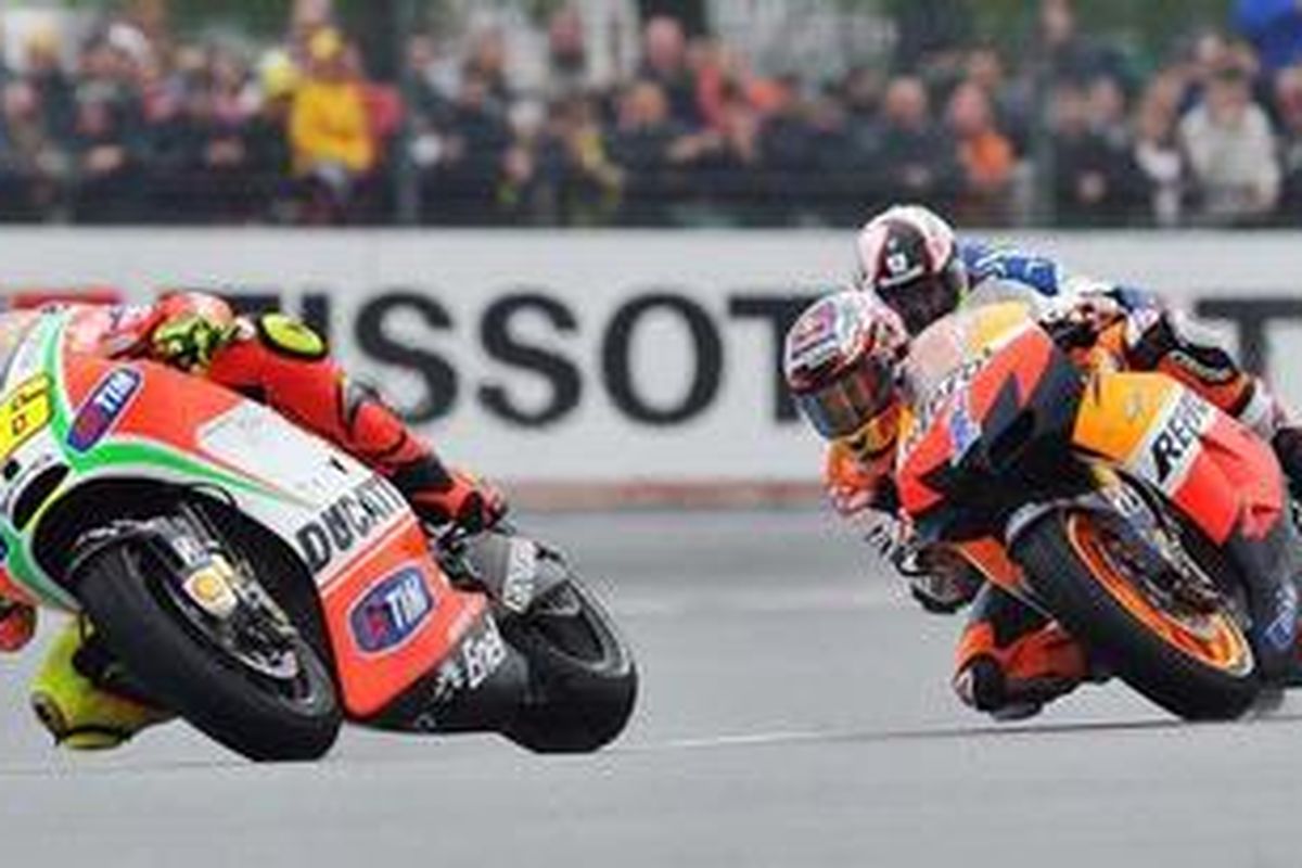 Pebalap Ducati, Valentino Rossi (kiri), ketika menyalip pebalap Repsol Honda, Casey Stoner, dalam pertarungan perebutkan posisi kedua GP Perancis, Minggu (20/5/2012). Rossi jadi pemenang.