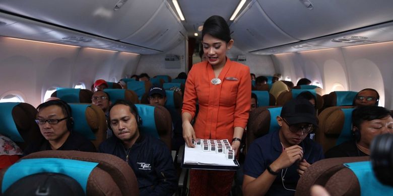 Pramugari maskapai Garuda Indonesia membagikan coklat geratis kepada penumpang saat  penerbangan bertajuk Kartini Flight dalam perjalanan menuju Bandara Minangkabau Padang, Sumatera Barat, Jumat (21/4/2017). Garuda Indonesia menggelar Kartini Flight dalam rangka menyambut Hari Kartini. Seluruh petugas penerbangan dari pilot, pramugari hingga teknisi adalah perempuan.