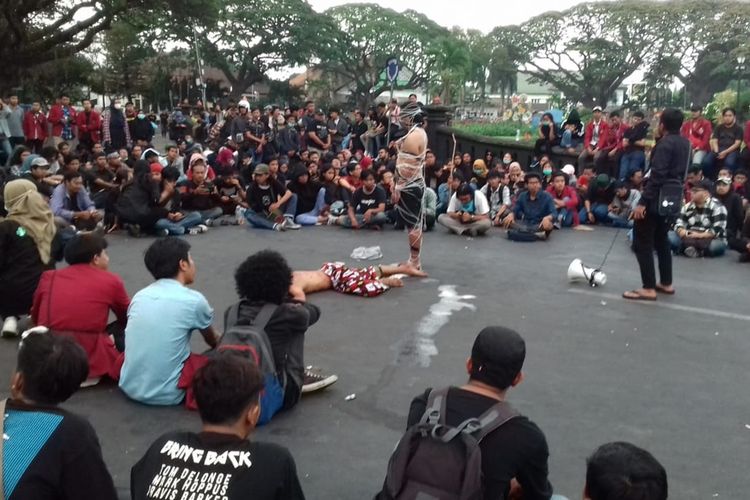 Massa aksi mahasiswa menggelar teatrikal usai menyampaikan orasi di depan Gedung DPRD Kota Malang, Selasa (24/9/2019)