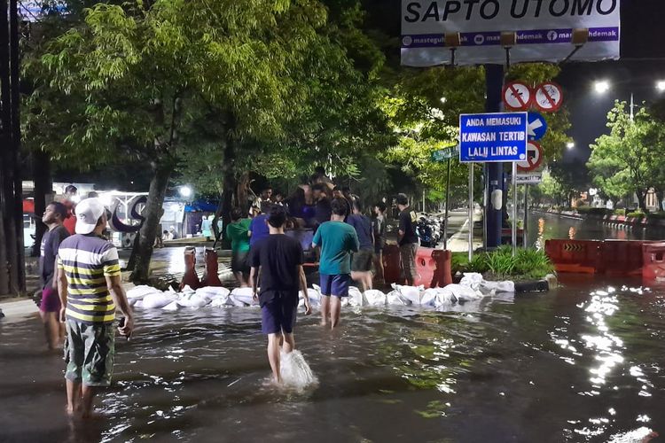 Warga Kampung Bogorame, Demak ramai-ramai bendung ruas jalan Sultan Fatah untuk menghalau banjir, Senin (18/3/2024) malam. (KOMPAS.COM/NUR ZAIDI)