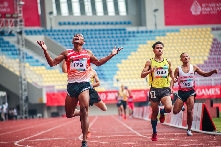 Atlet para atletik Indonesia, Endi Nurdin Tine (kiri), meraih medali emas ASEAN Para Games 2022 nomor 1500 meter T20 di Stadion Manahan, Solo, Selasa (2/8/2022).