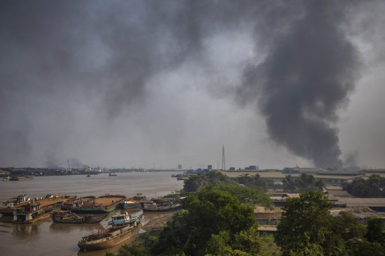 Serangan terhadap pabrik China menimbulkan asap hitam mengepul dari zona industri kotapraja Hlaing Thar Yar di Yangon, Myanmar Minggu, 14 Maret 2021. 