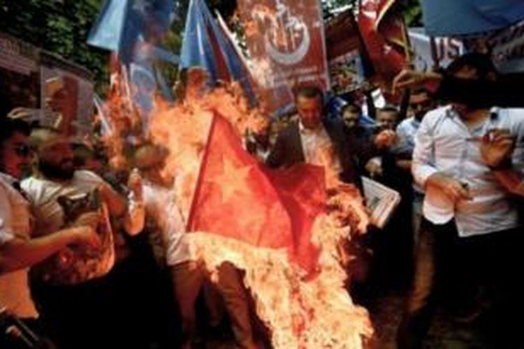 Ratusan pengunjuk rasa membakar bendera China dalam sebuah unjuk rasa di depan kedutaan besar negeri itu di Ankara, Turki.