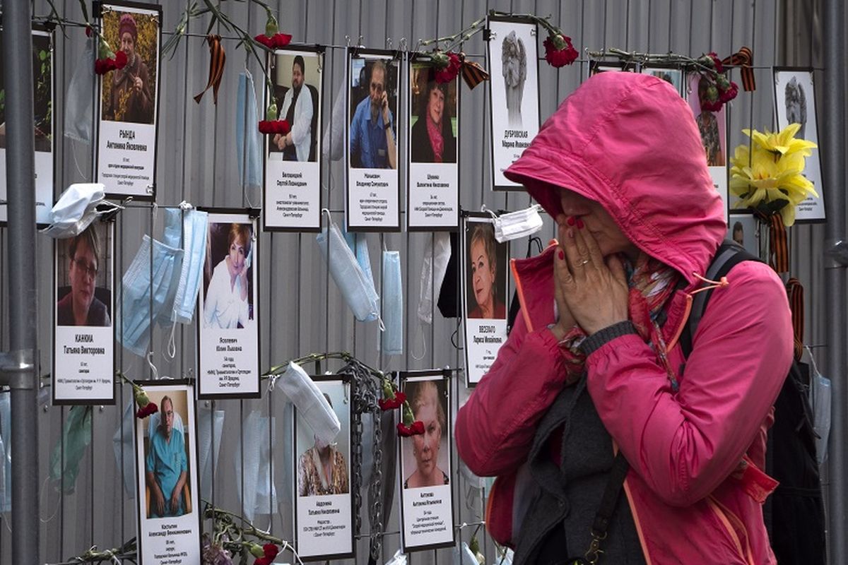 Foto ini diambil pada Rabu, 20 Mei 2020, tampak seorang wanita bereaksi ketika dia berjalan melewati potret pekerja medis Saint Petersburg yang meninggal akibat terinfeksi virus corona selama melakukan pekerjaan mereka.