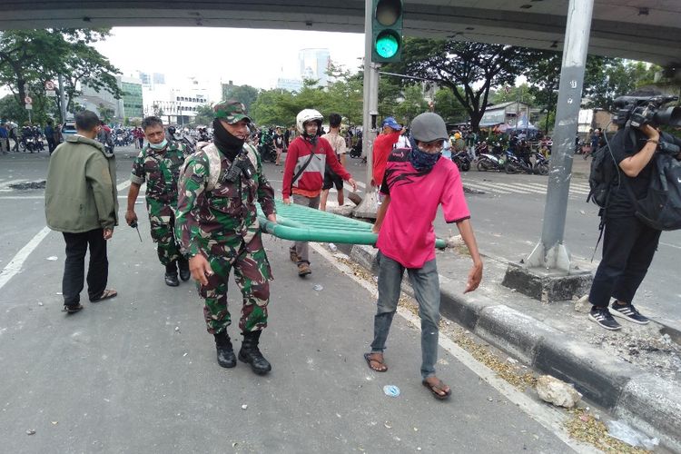 TNI dan Anggota Masa Alis 22 Mei Saling Bantu Bereskan Besi Trotoar Yang Lepas di Jalan Jati Baru Raya, Tanah Abang, Jakarta Pusat, Rabu (22/5/2019)