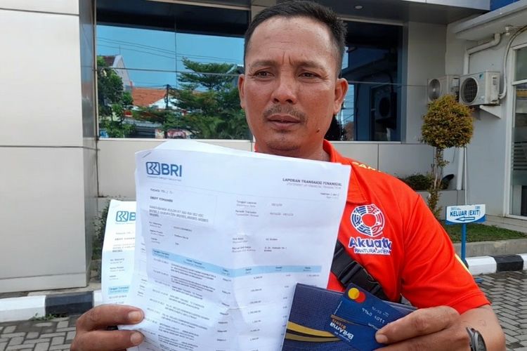 Dedy Yohanes (45) warga Desa Randusanga Kulon, Kabupaten Brebes, Jawa Tengah menunjukan rekening koran BRI dimana saldo di rekening tabungan miliknya hilang Rp 213 juta secara misterius, di halaman Kantor BRI di Brebes, Jumat (1/12/2023).