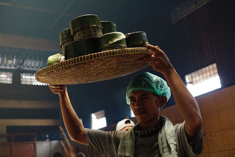 A worker prepares an arrangement of banana leaves to wrap basket cakes at the Dodol and Kue Ny. Lauw (LKW), in Tangerang, Banten, Friday (17/1/2025).