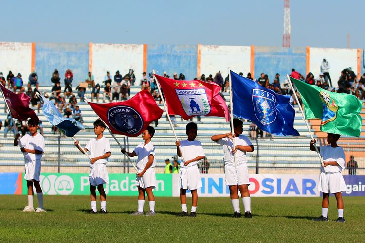 Sejumlah anak membawa bendera perwakilan peserta saat ceremonial pembukaan Liga 2 2023-2024 yang berlangsung di Stadion Surajaya Lamongan, Minggu (10/9/2023) sore.