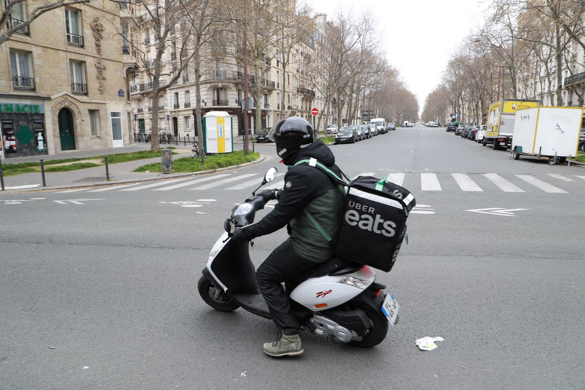 Seorang driver Uber Eats melintas di Paris, Perancis, pada 22 Maret 2020, saat lockdown ketat diterapkan untuk menekan penyebaran Covid-19.