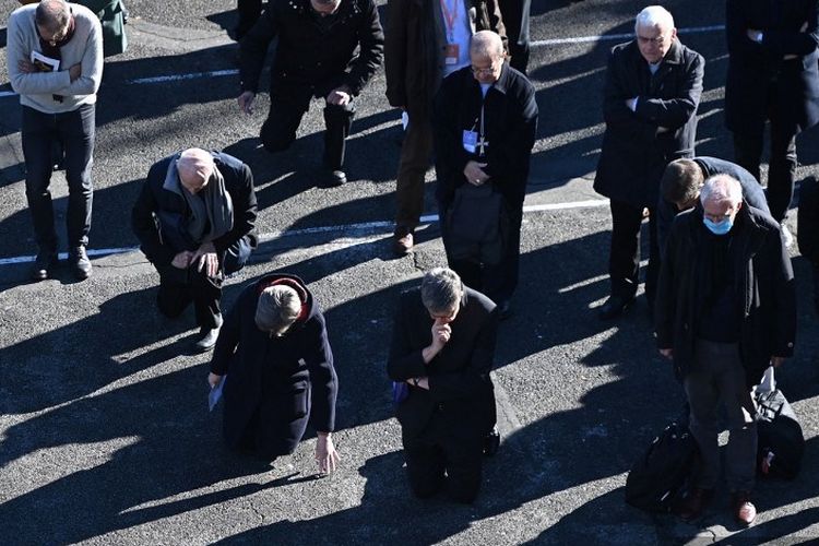 Para uskup gereja Katolik berlutut sebagai tanda penebusan dosa selama upacara di tempat kudus Lourdes terhadap para korban pedokriminalitas di Lourdes, Perancis barat daya pada 6 November 2021. 