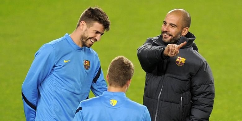 Bek FC Barcelona, Gerard Pique (kiri), berbincang-bincang dengan Josep Guardiola saat sesi latihan di Stadion Camp Nou, 5 Desember 2011.