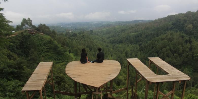 Sepasang wisatawan saat berpose pada spot I Love You di Batu Flower Garden, Coban Rais, Kota Batu, Jawa Timur, Sabtu (21/1/2017).