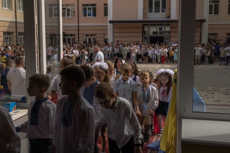 Murid-murid memasuki sekolah dalam sebuah upacara untuk menandai dimulainya tahun ajaran baru, yang dikenal sebagai 'Hari Pengetahuan' di Irpin, barat laut Kyiv, pada 1 September 2023, di tengah invasi Rusia ke Ukraina.