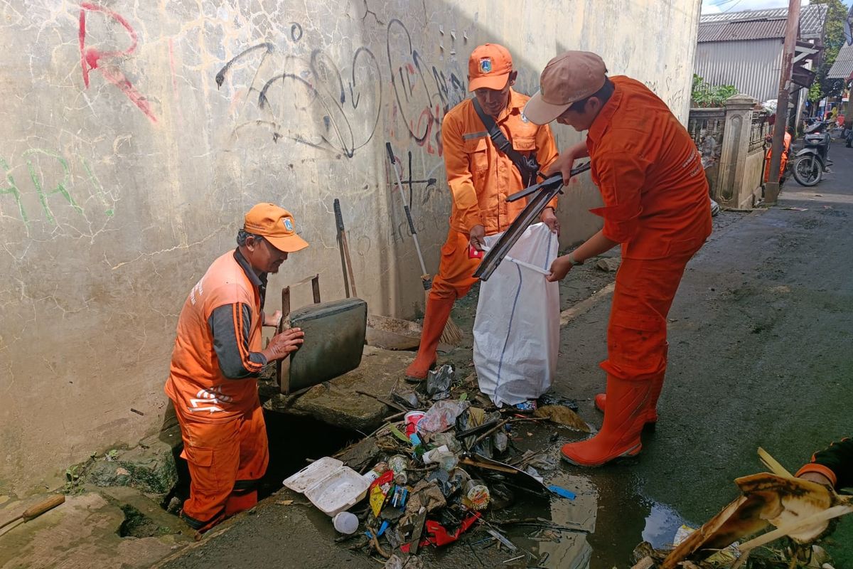 Petugas PPSU Kelurahan Kampung Rambutan membersihkan berbagai jenis sampah pascabanjir di Kawasan RT 04 dan RT 12 RW 02, Kelurahan Kampung Rambutan, Kecamatan Ciracas, Jakarta Timur, Senin (20/2/2023).