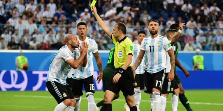 Wasit Cuneyt Cakir memberi kartu kuning kepada Javier Mascherano yang melakukan pelanggaran di kotak penalti Argentina kepada pemain Nigeria di Stadion Krestovsky, 26 Juni 2018. 