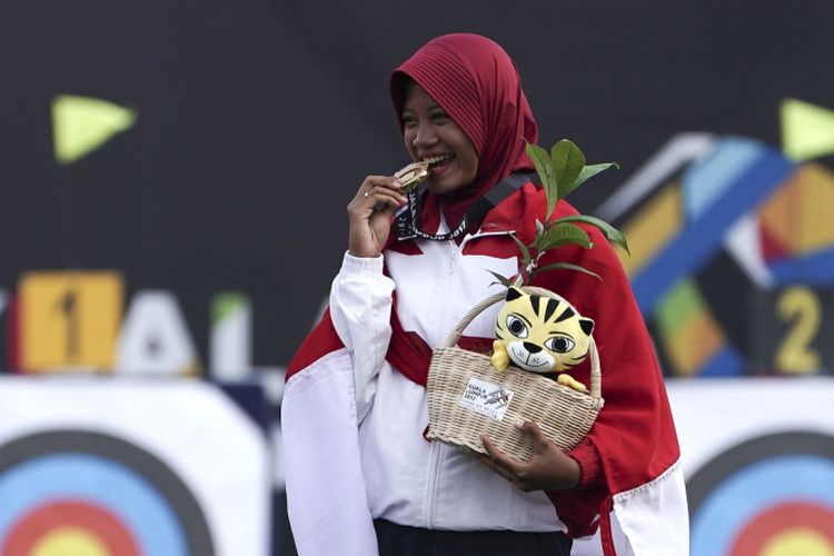 Atlet panahan Indonesia Diananda Choirunnisa menggigit medali emas ketika upacara penganugerahan medali panahan nomor recurve putri di  Synthetic Turf Fild, Kawasan Bukit Jalil, Malaysia, Minggu (20/8/2017). Diananda Choirunnisa berhasil memperoleh medali emas setelah menang atasNicole Marie Tagle asal Filipina dengan skor 6-4.