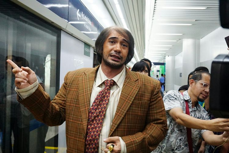 Tampil sebagai karakter Bossman dari film My Stupid Boss 2, artis peran Reza Rahadian memakai mengantre untuk memasuki MRT rute Bundaran HI-Lebak Bulus, Jumat (29/3/2019).
