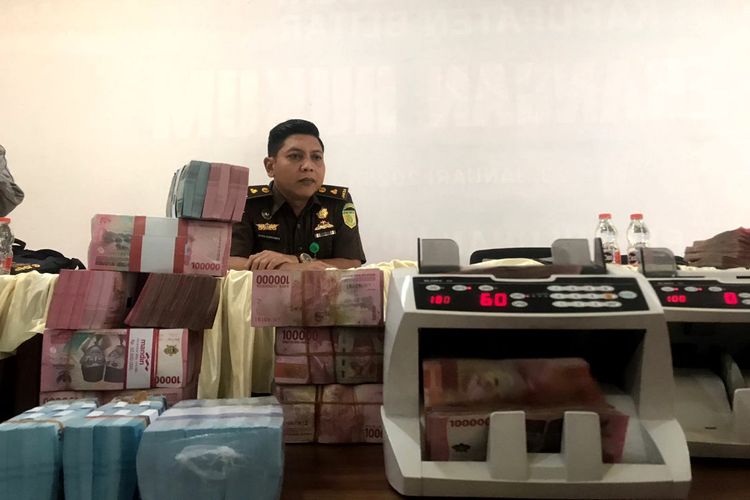 Penyidik Kejaksaan Negeri Kabupaten Blitar memajang uang pecahan Rp 100.000 dan Rp 50.000 senilai Rp 1,1 miliar yang dititipkan tersangka kasus dugaan korupsi pembangunan Dam Kalibentak, Muhammad Muchlison alias Gus Ison, Senin (23/6/2025).