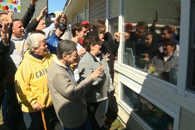 Perayaan ulang tahun ke 100 Millie Erickson, penghuni panti jompo Sterling Village di Sterling, Massachusetts, AS, dilakukan dari balik jendela.  