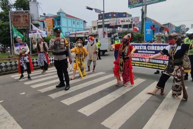 Jajaran Polresta Cirebon Jawa Barat melakukan kampanye operasi keselamatan berlalu lintas di Jalur Utama Pantura, Simpang Palimanan, Kabupaten Cirebon, Jawa Barat, Selasa (7/2/2023). Mereka menghadirkan kearifan lokal dengan tokoh punakawan dan tari topeng selama kegiatan berlangsung. pesan pesan keselamatan berlalu lintas juga terus dikampanyekan