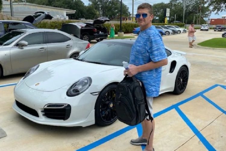 Casey William Kelley bersama dengan mobil Porsche 911 Turbo yang dibelinya. Dia ditangkap sehari kemudian setelah diketahui cek yang digunakannya untuk membeli mobil palsu.