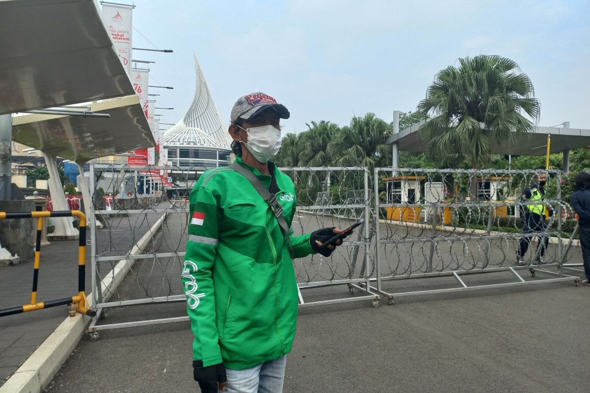 Pengemudi Ojek Online, Rudi Sahlan (53), saat membatalkan pesanan masuk karena Mal Margo City, Depok, ditutup sementara, Mjnggu (22/8/2021).