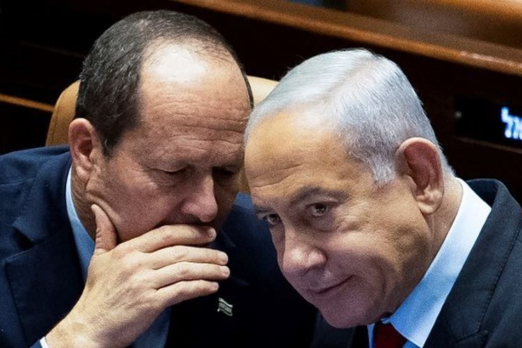 Menteri Ekonomi Israel Nir Barkat (kiri) berbicara dengan Perdana Menteri Benjamin Netanyahu di Knesset di Yerusalem pada 22 Februari 2023 saat pembacaan pertama klausul kontroversial dalam reformasi peradilan. Barkat menyebut hubungan perdagangan Israel dengan negara-negara Arab tak terpengaruh perang Gaza. 
