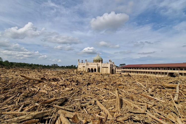 Tumpukan kayu yang terbawa banjir dan longsor di Pondok Pesantren Darul Mukhlisin, Aceh Tamiang, masih belum dievakuasi, Jumat (13/12/2025).
