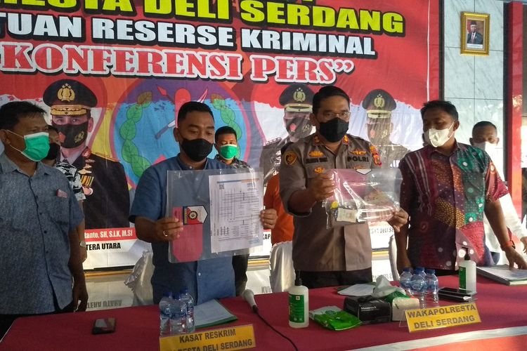 Wakapolresta Deli Serdang, AKBP Julianto P. Sirait didampingi Kasatreskrim Polresta Deli Serdang, Kompol M. Firdaus dan Wakasatreskrim menunjukkan barang bukti kasus pemalsuan surat hasil PCR swab test bertuliskan Klinik Jemadi. Seorang pria berinisial AHM (51) ditetapkan sebagai tersangka. Pelaku sudah dua kali menjual surat palsu. Yang pertama sudah berhasil lolos terbang.