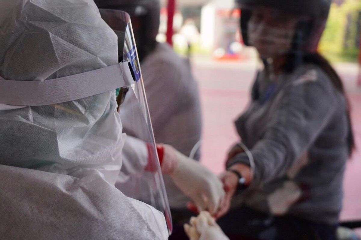 A health worker is performing a COVID-19 rapid test.