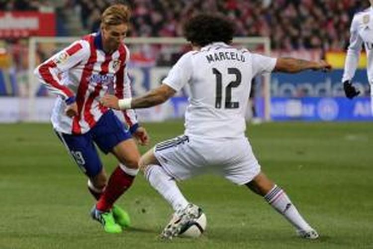 Striker Atletico Madrid, Fernando Torres (kiri), mencoba melewati hadangan bek Real Madrid, Marcelo (kanan), pada laga leg pertama babak 16 besar Copa del Rey di Vicente Calderon, Madrid, Rabu (7/1/2015).