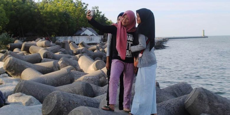 Pengunjung berswafoto di Pantai Bangka Jaya, Kecamatan Dewantara, Kabupaten Aceh Utara, Aceh, Senin (13/5/2019).