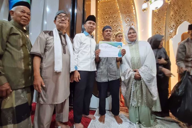 Baharuddin (43) bersama pengurus Masjid Babussa'adah saat mendapatkan sertifikat umrah gratis, Senin (25/3/2023) malam