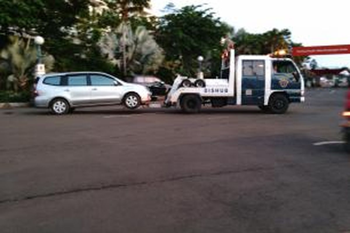 Sebuah mobil diderek oleh petugas Dishub DKI di dalam Ancol. Banyak kendaraan yang parkir sembarangan di bahu jalan pada perayaan tahun baru ini. Kamis (31/12/2015)