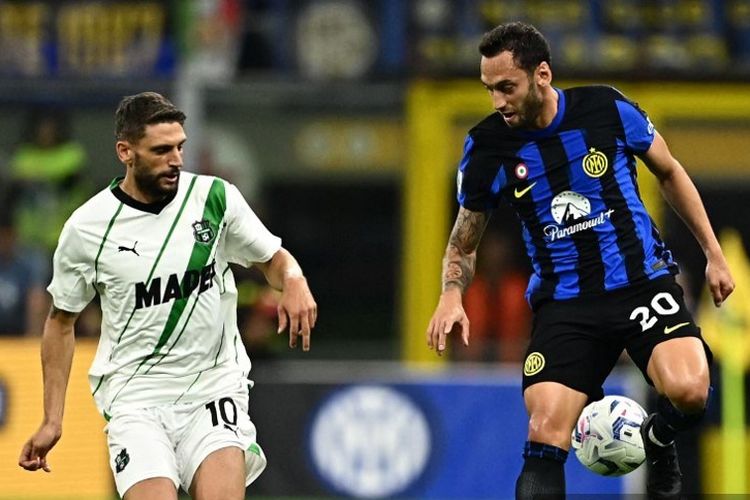 Duel Domenico Berardi (kiri) dengan Hakan Calhanoglu (kanan) dalam laga pekan keenam Liga Italia 2023-2024 antara Inter vs Sassuolo, 27 September 2023. (Photo by GABRIEL BOUYS / AFP)