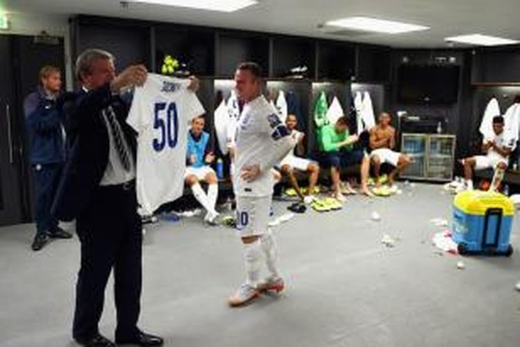 Pelatih Inggris, Roy Hodgson, memberikan kostum bernomor 50 kepada striker Wayne Rooney, Selasa (8/9/2015). 