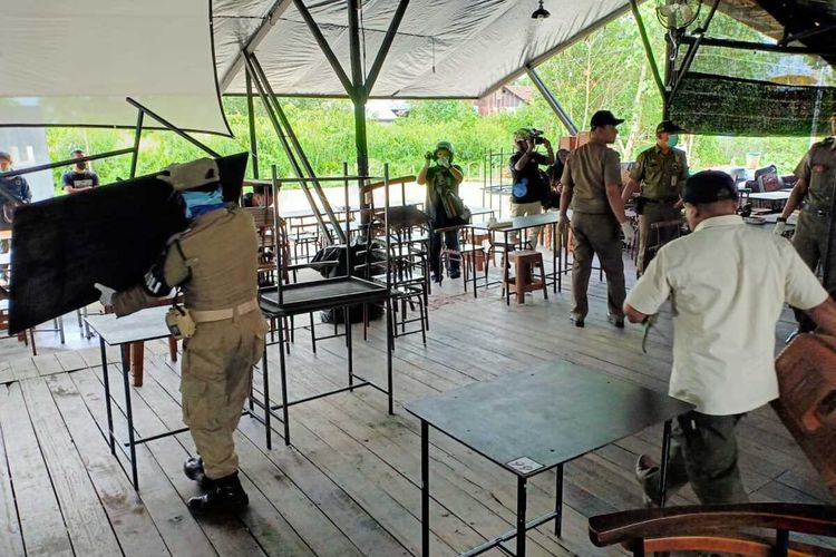 Satpol PP Kota Pontianak, Kalimantan Barat, mengemasi warkop yang menyediakan kursi dan meja di Jalan Reformasi, Kecamatan Pontianak Tenggara, Kota Pontianak, Kalimantan Barat.