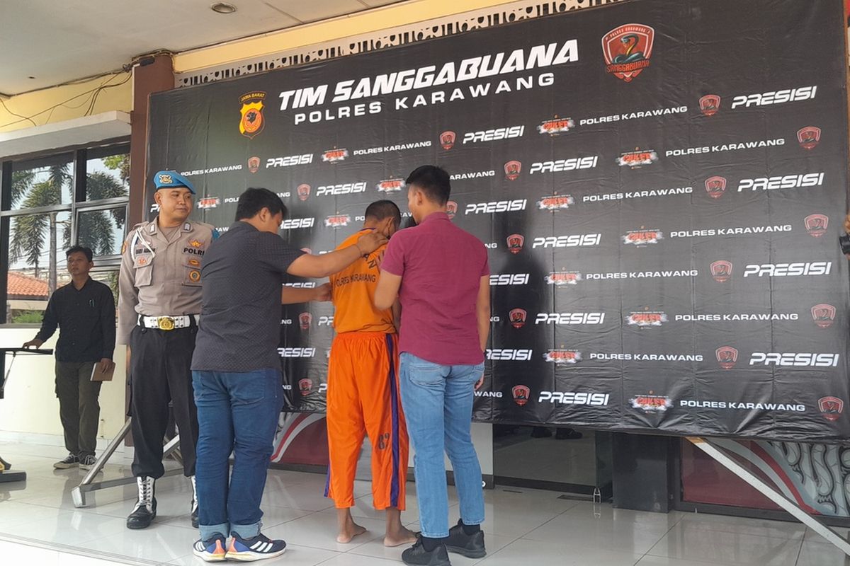 OS (38), bandar judi togel online di Desa Karangsinom, Kecamatan Tirtamulya, Kabupaten Karawang, Jawa Barat, saat press release di Mapolres Karawang, Jumat (4/8/2023).