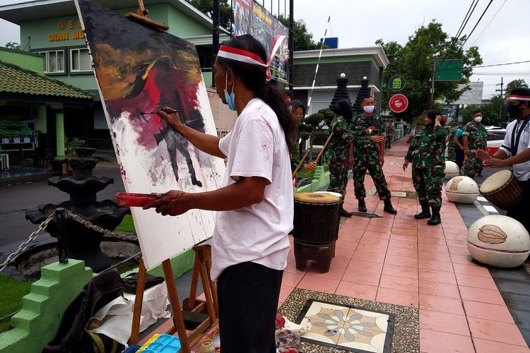 Perupa Sony Yuliono melukis cepat di depan Markas Kodim 0808/Blitar memeringati pemberontakan PETA di Blitar, Senin (14/2/2022)