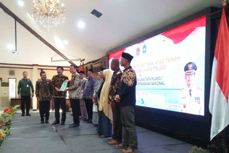Menteri ATR/Kepala BPN Hadi Tjahjanto bersama Bupati Lamongan Yuhronur Efendi (tengah), saat penyerahan sertifikat tanah secara simbolis kepada pemiliknya di Pendopo Lokatantra, Lamongan, Jawa Timur.