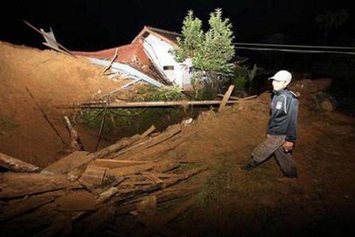 Seorang warga melintas diantara reruntuhan rumah di perkampungan dan pabrik pengolahan teh hijau di Kampung Dewata, Kecamatan Pasir Jambu,Kabupaten Bandung, Selasa (23/2/2010). Longsor tersebut menimbun 80 kepala keluarga di wilayah sana.