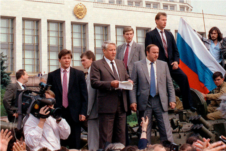 Runtuhnya Uni Soviet: Presiden Rusia, Boris N. Yeltsin (tengah) berdiri di atas kendaraan lapis baja yang diparkir di depan Gedung Putih di Moskow, dengan para pendukung memegang bendera Federasi Rusia, 19 Agustus 1991.
