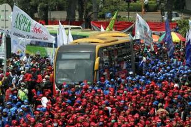 Massa buruh yang tergabung dalam Gerakan Buruh Indonesia berdemonstrasi melintasi Jalan Medan Merdeka Barat, Jakarta Pusat, Selasa (1/9/2015). Demonstrasi dilakukan karena adanya ancaman PHK besar-besaran seiring dengan anjloknya nilai tukar rupiah terhadap dolar AS.