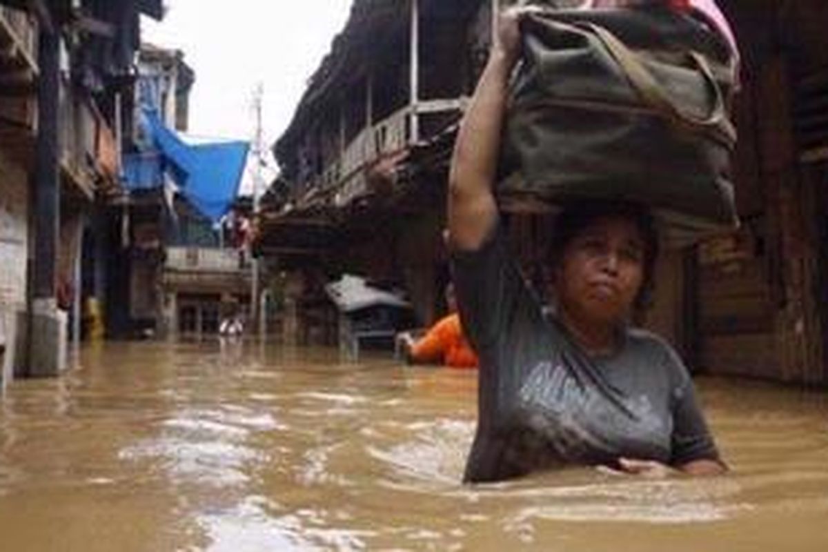 Warga melintasi banjir yang merendam kawasan Kampung Melayu Kecil, Bukit Duri, Jakarta Selatan, Kamis (18/2/2010). 